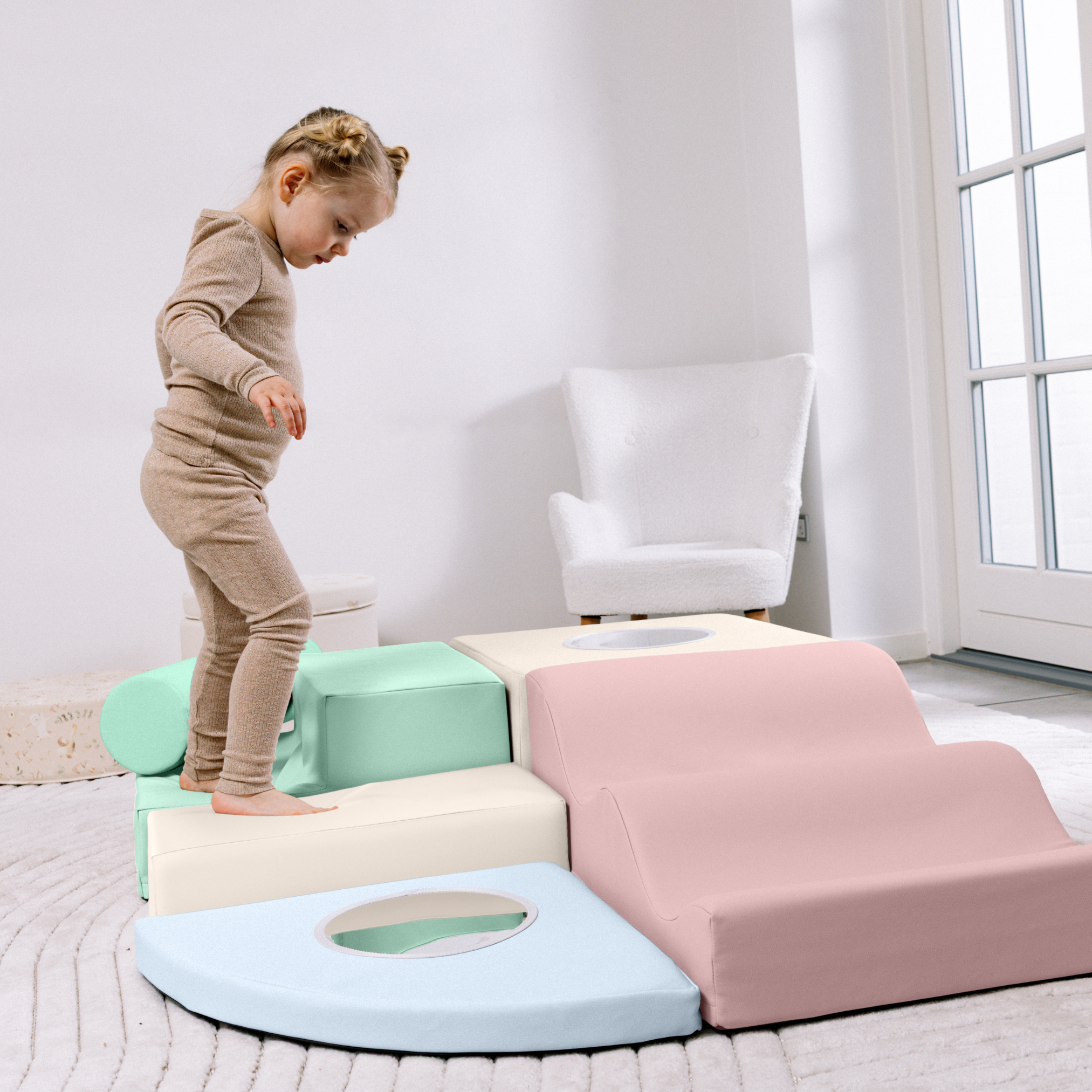 Child playing on a soft play structure in a bright room